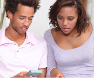 A young couple reading something on a smartphone