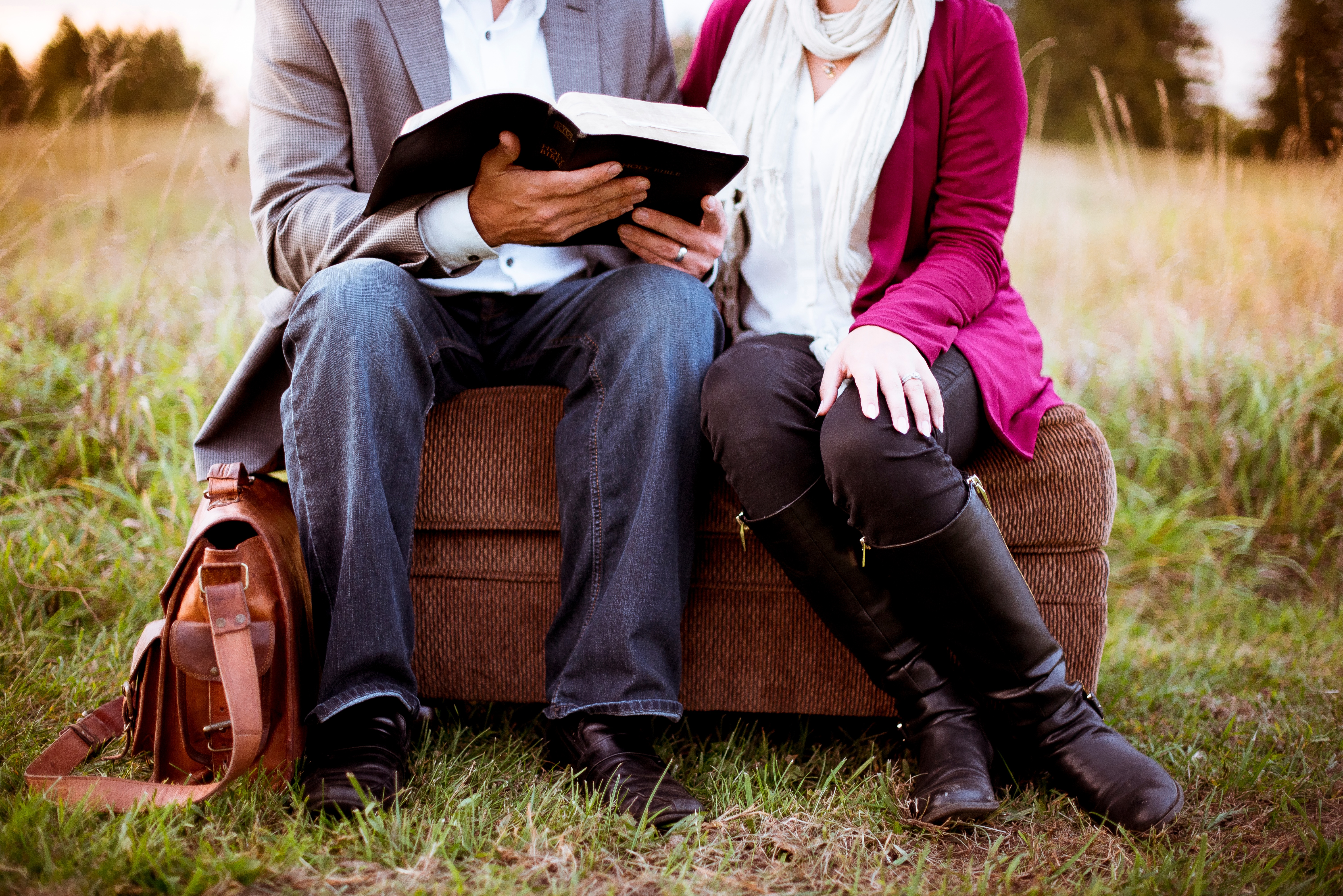 Couple read together in a field